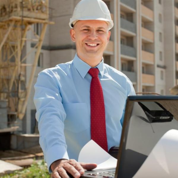 man-in-white-hard-hat-with-computer-at-building-site